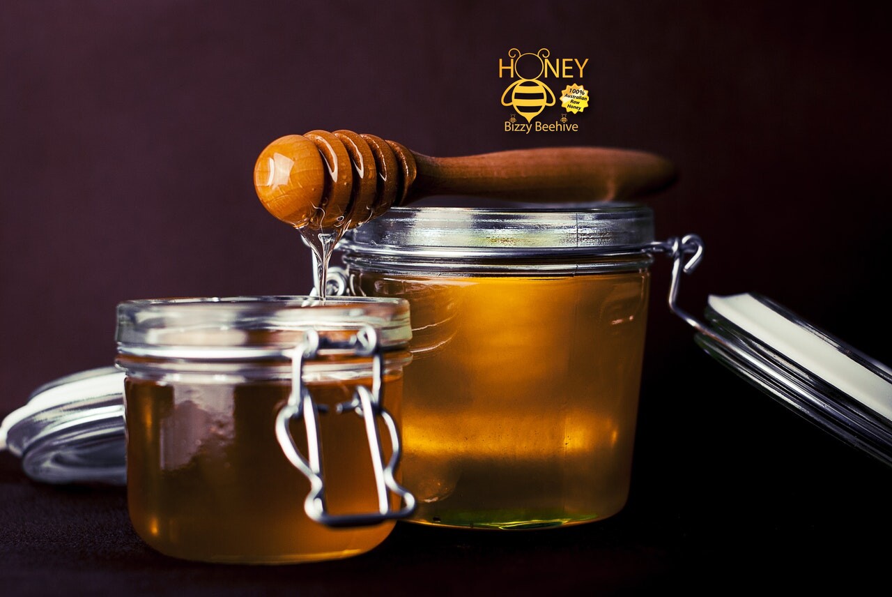 Raw Bizzy Beehive honey being drizzled from a wooden dipper